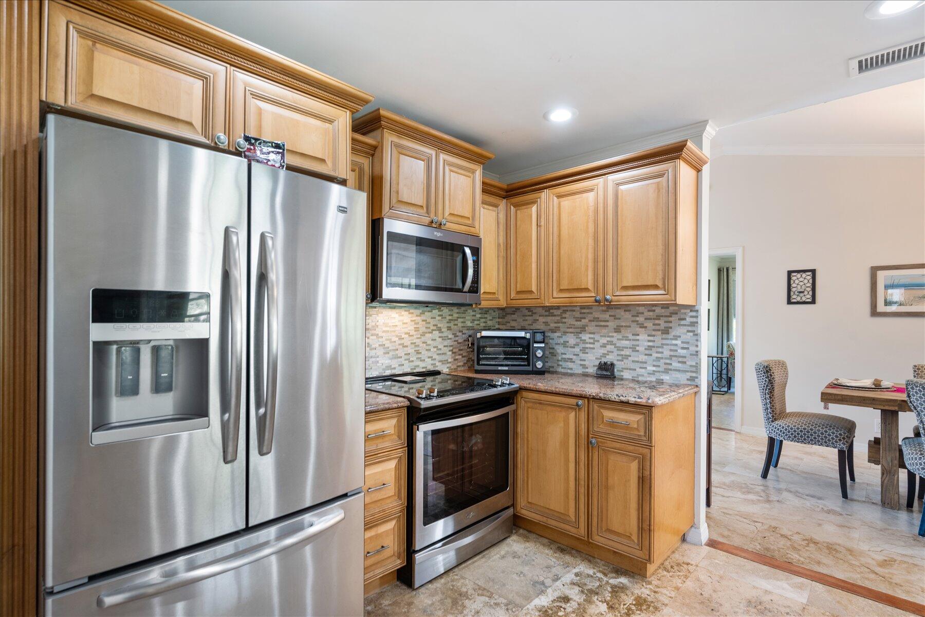 13889 Geranium Place Wellington, FL 33414 - Photo 11 of 32 a kitchen with stainless steel appliances granite countertop a refrigerator and a stove top oven