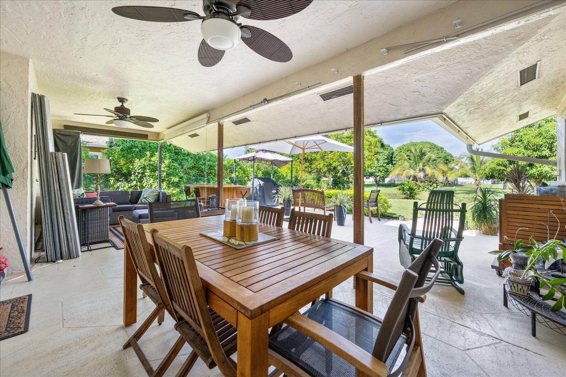 13889 Geranium Place Wellington, FL 33414 - Photo 15 of 32 a view of a patio with a table chairs and a potted plant