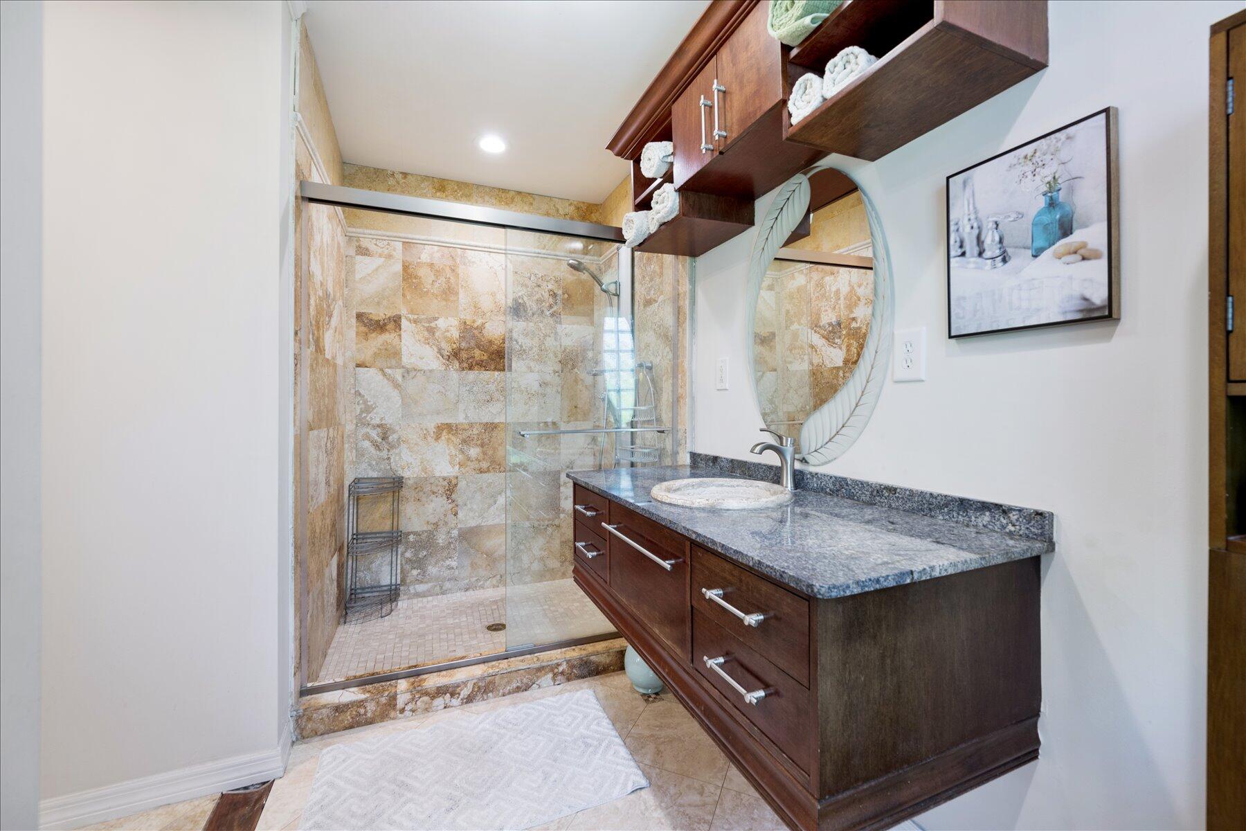 13889 Geranium Place Wellington, FL 33414 - Photo 25 of 32 a room with a granite countertop sink a mirror and shower