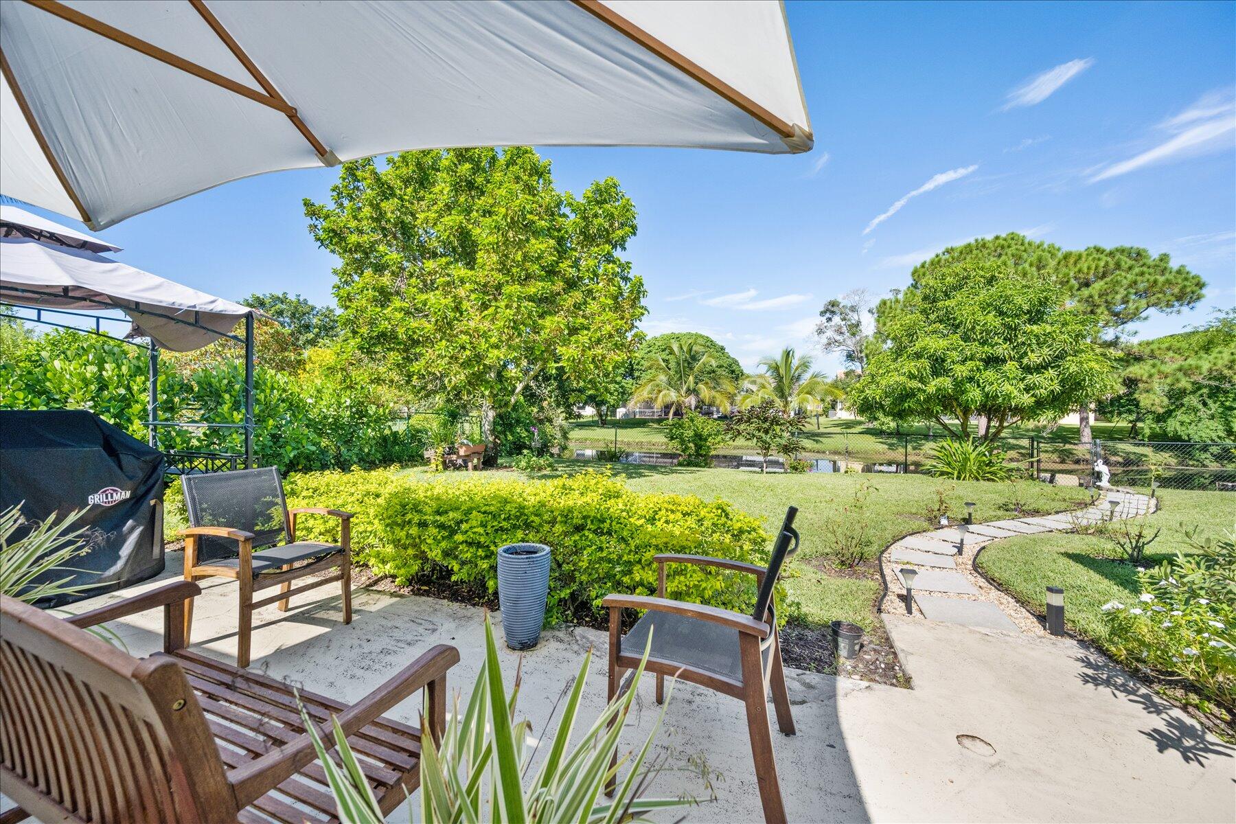 13889 Geranium Place Wellington, FL 33414 - Photo 26 of 32 a view of yard with seating area and green space