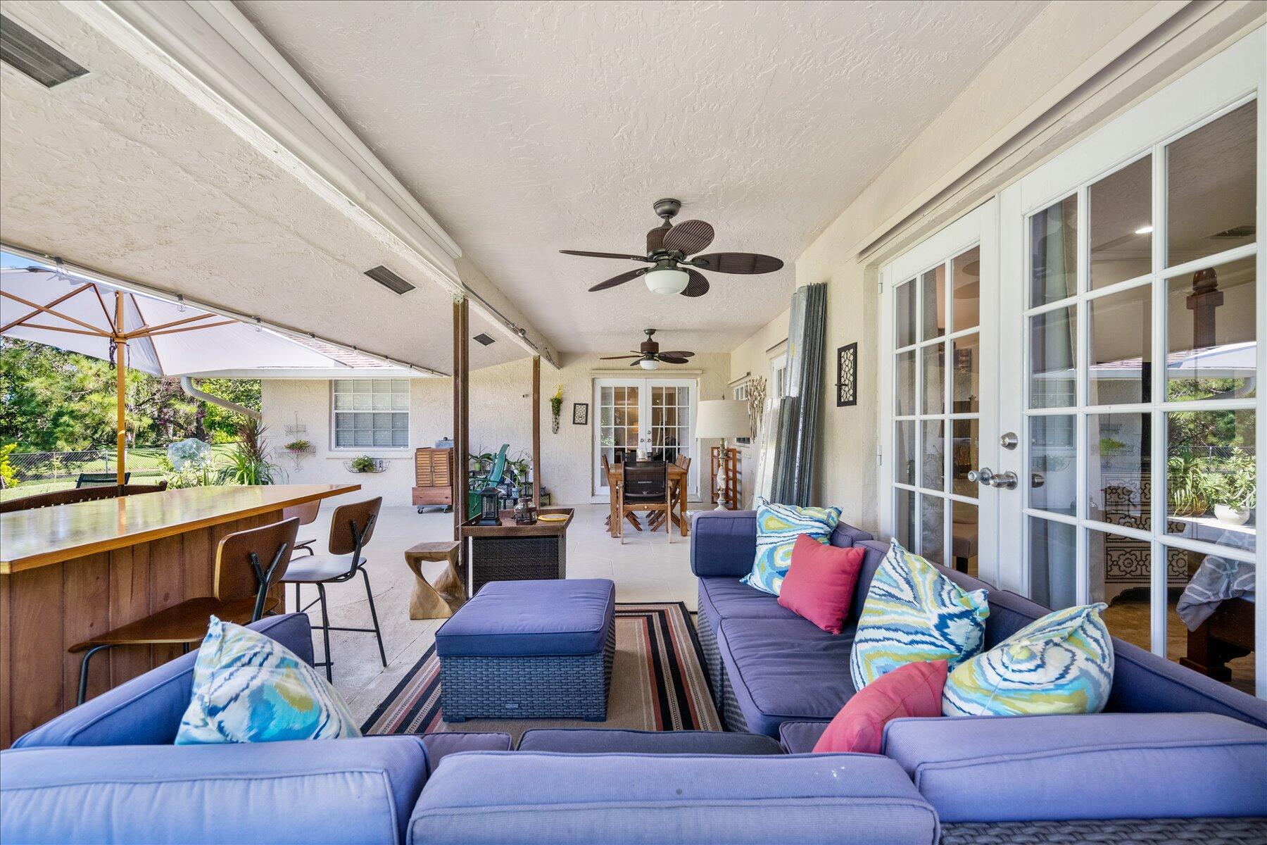 13889 Geranium Place Wellington, FL 33414 - Photo 27 of 32 a living room with furniture and a large window