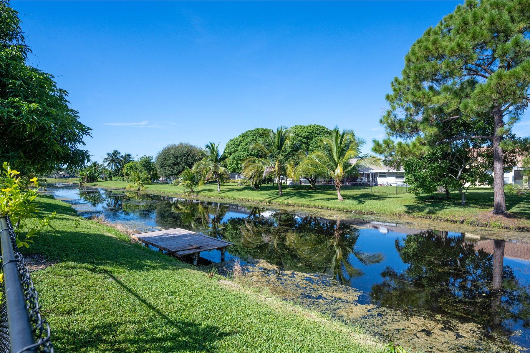 13889 Geranium Place Wellington, FL 33414 - Photo 32 of 32 a view of a garden with a lake