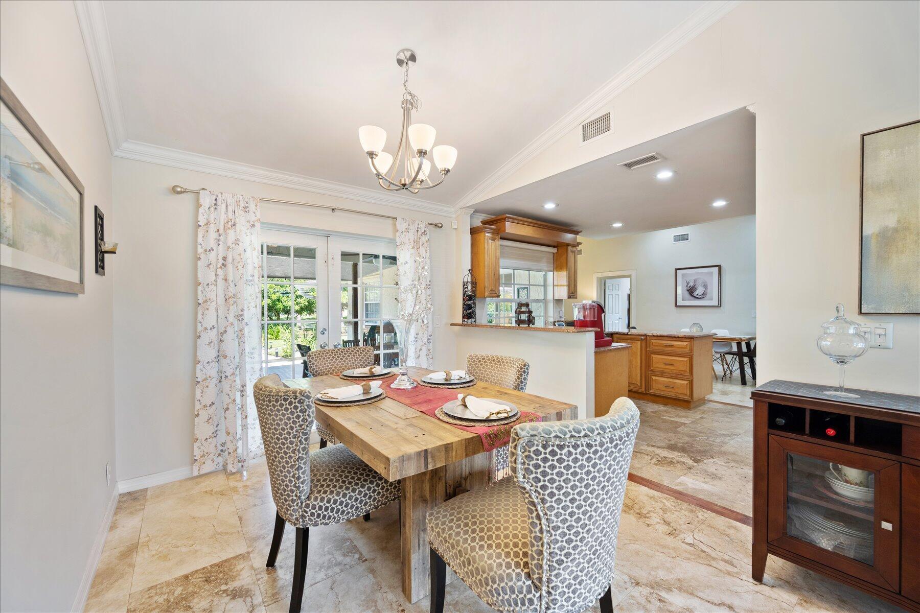 13889 Geranium Place Wellington, FL 33414 - Photo 7 of 32 a view of a dining room with furniture a chandelier and wooden floor