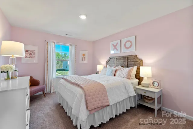 a bedroom with a bed and a lamp on dresser