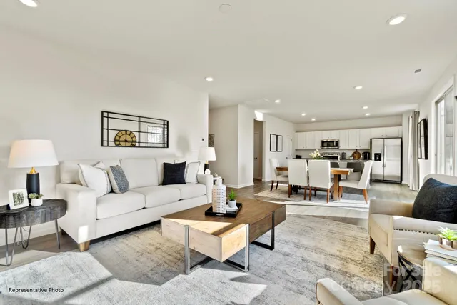 a living room with furniture and view of kitchen