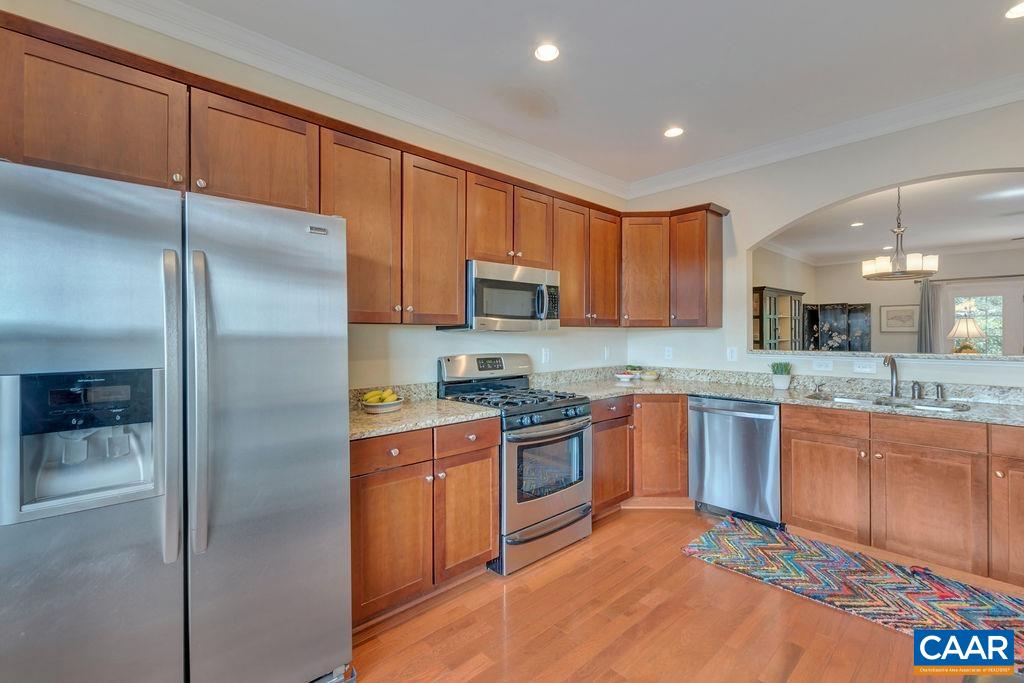 329 Quarry Road Charlottesville, VA 22902 - Photo 14 of 45 a kitchen with stainless steel appliances granite countertop a refrigerator a sink a stove with wooden cabinets and floors