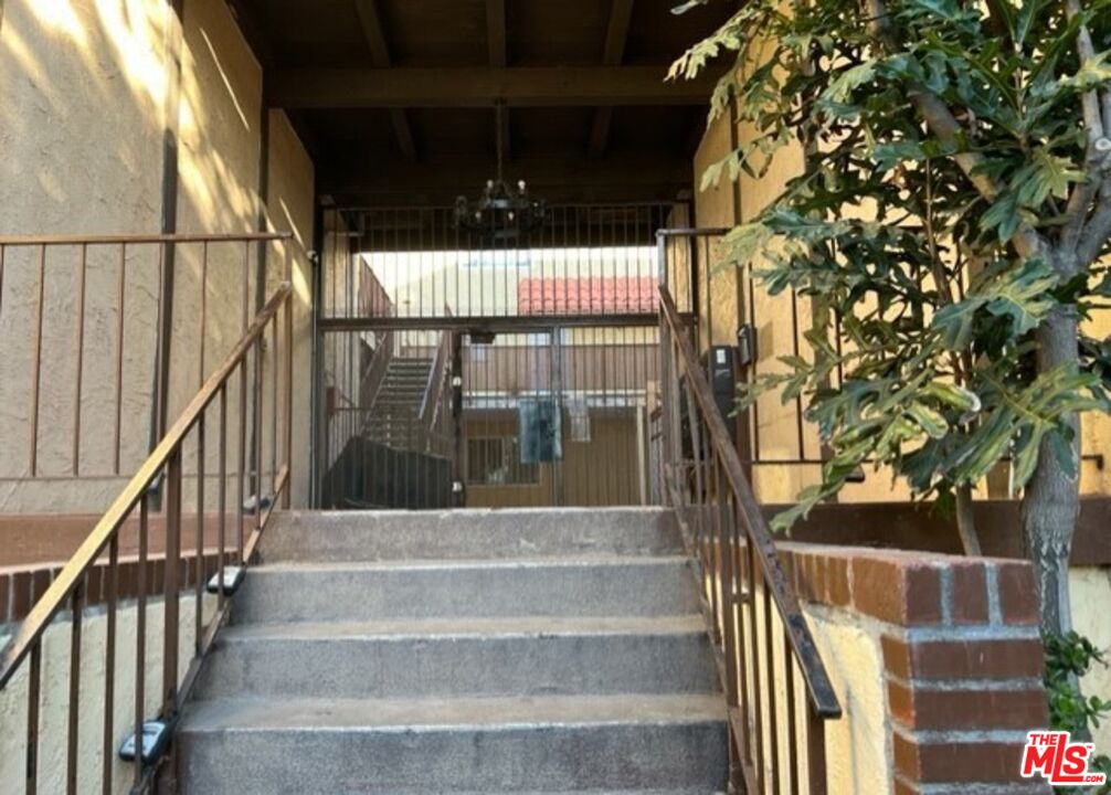 a view of staircase with railing and a potted plant