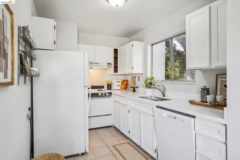 a kitchen with white cabinets and white appliances