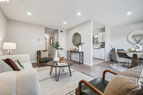 a living room with furniture a rug and a mirror