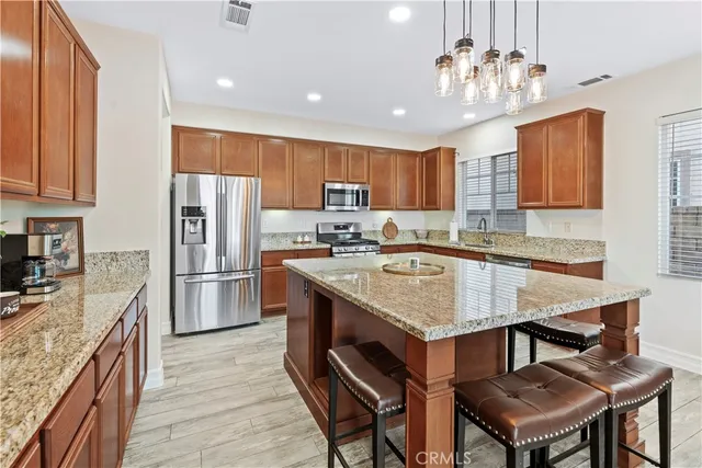 a kitchen with stainless steel appliances granite countertop a sink stove and refrigerator