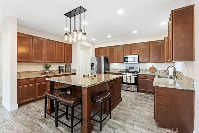 a kitchen with kitchen island granite countertop wooden cabinets a center island and appliances