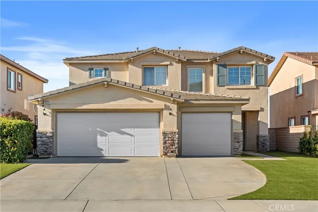 front view of a house with a yard and a garage