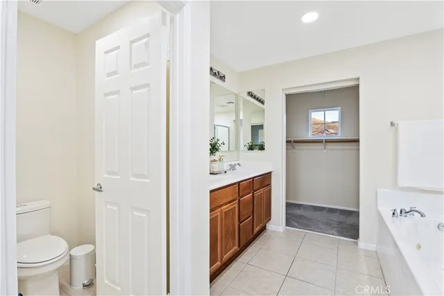 a spacious bathroom with a bathtub sink mirror and toilet
