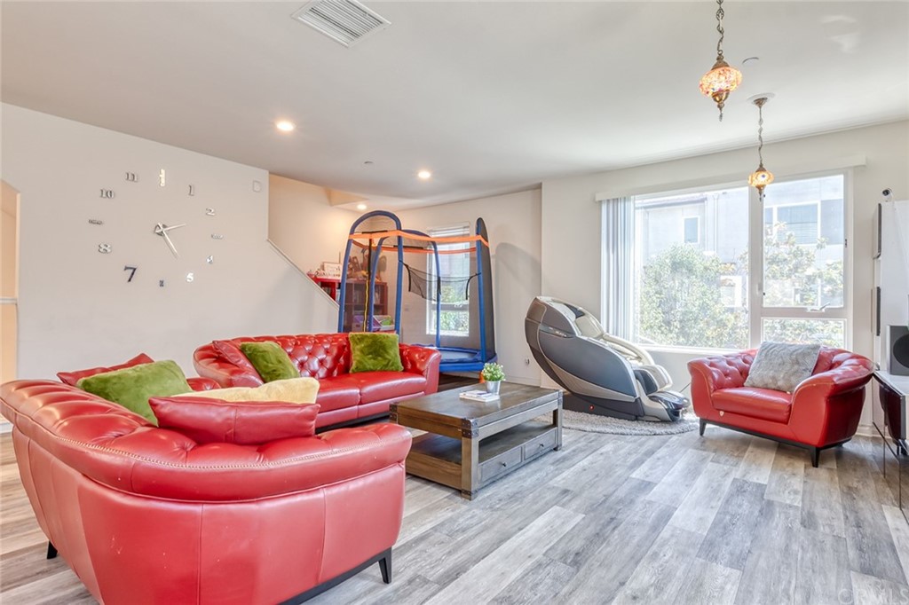 8000 Olive Lane Downey, CA 90241 - Photo 11 of 39 a living room with furniture a large window and wooden floor