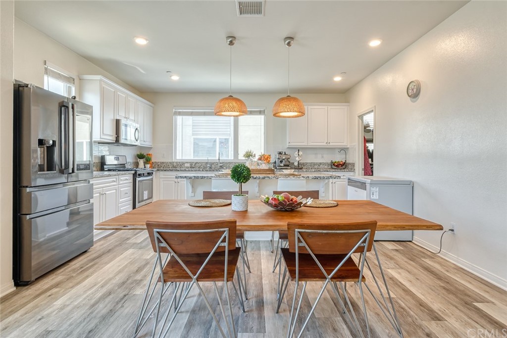 8000 Olive Lane Downey, CA 90241 - Photo 4 of 39 a view of a dining room with furniture and wooden floor