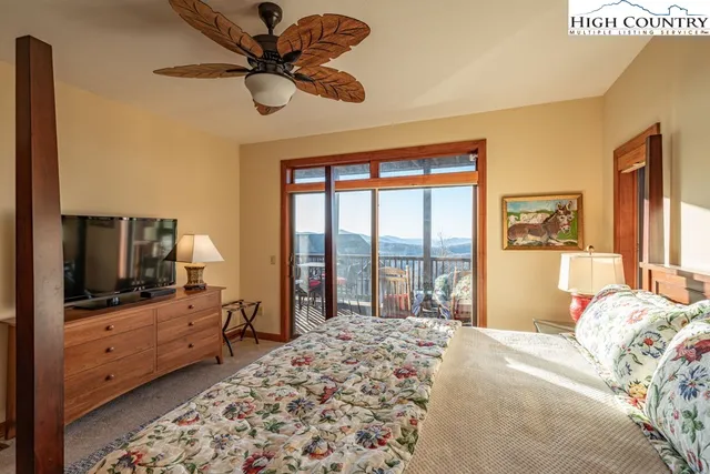 a bedroom with a bed and a flat tv screen on dresser