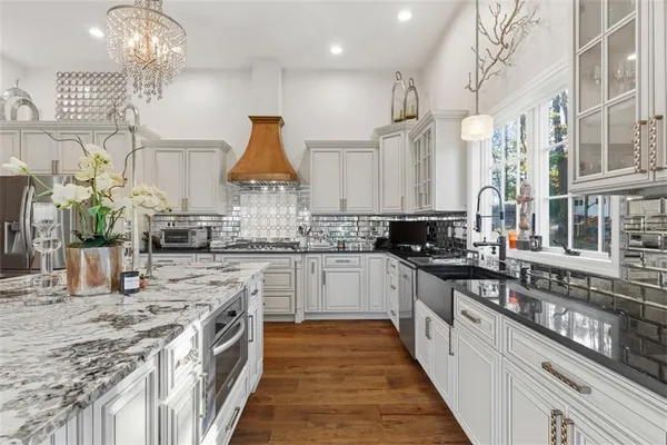 a living room with furniture a large window and wooden floor
