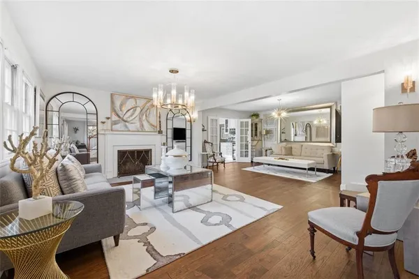 a living room with furniture a fireplace and a chandelier