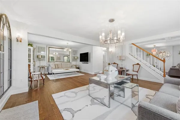 a living room with furniture a flat screen tv and a large window