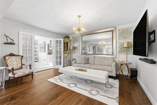 a living room with furniture a large window and a chandelier
