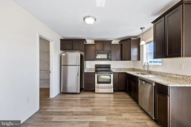 a kitchen with a refrigerator sink and cabinets