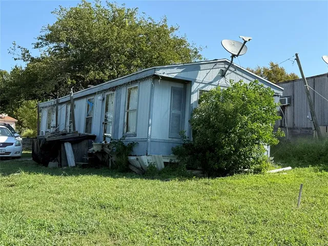 a view of a backyard with potted plants and large trees