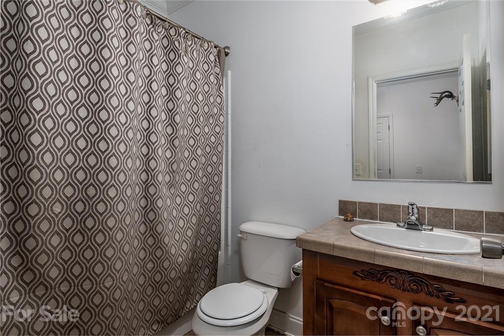 4478 Hickory Nut Ridge Road Hudson, NC 28638 - Photo 18 of 29 a bathroom with a granite countertop toilet and a sink