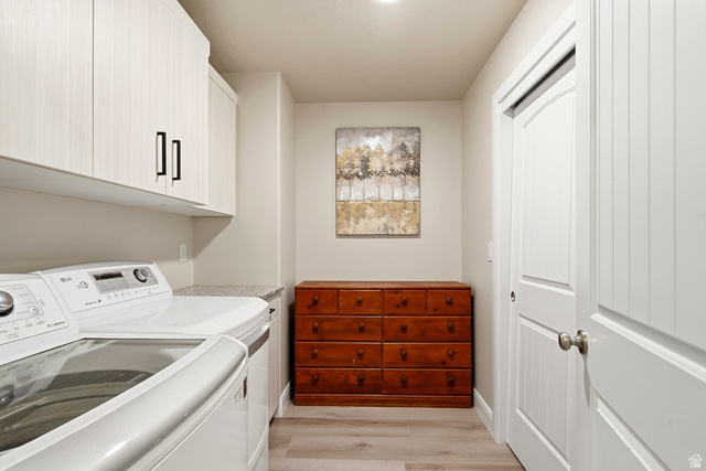 668 East Fiddlers Canyon Road, Unit 6 Cedar City, UT 84721 - Photo 27 of 36 Laundry area featuring light wood-finish flooring, white cabinetry with black hardware, and a speckled countertop