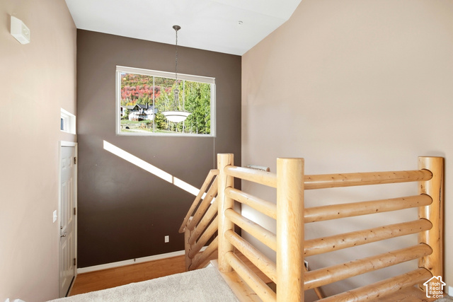 7396 Brook Hollow Loop Road Park City, UT 84098 - Photo 25 of 60 Vaulted ceilings, large picture window, wood-finish flooring, natural wood railing, and a pendant light fixture