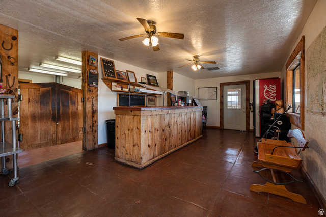 2040 North Long Cyn Road Kanab, UT 84741 - Photo 6 of 23 Kitchen featuring a textured ceiling, a ceiling fan, and wood finish cabinets