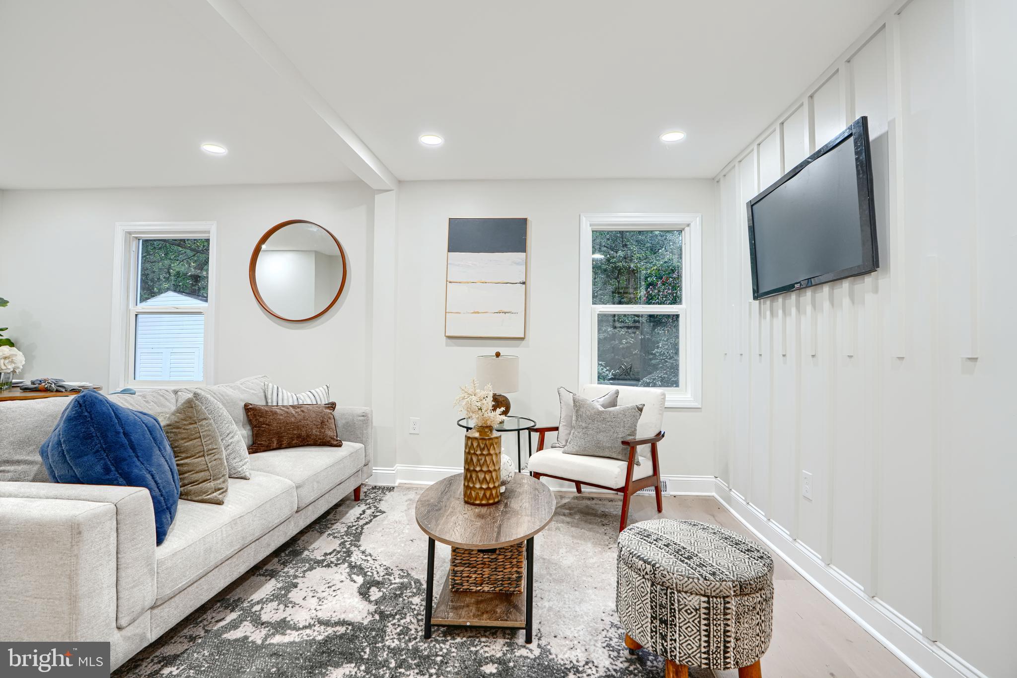 a living room with furniture a flat screen tv and a window