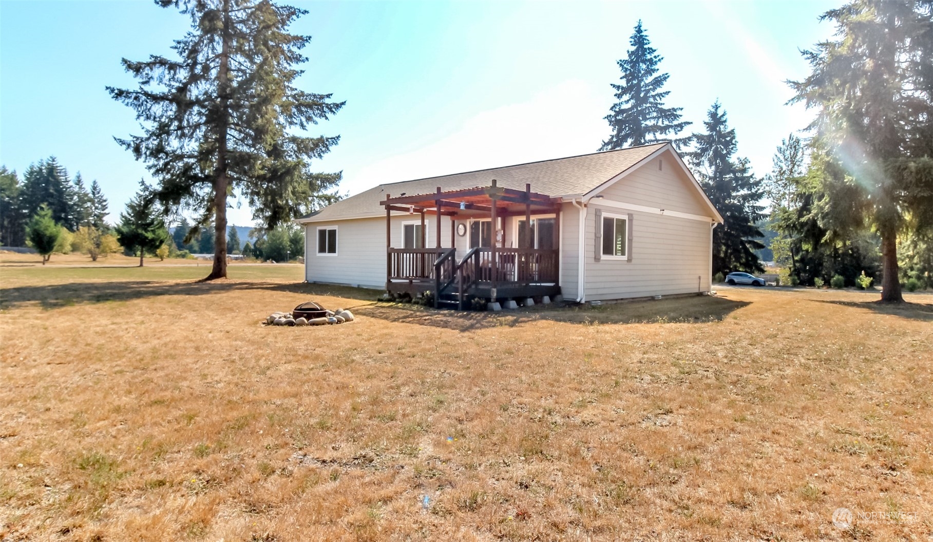 18217 Lawton Lane Southwest Rochester, WA 98579 - Photo 26 of 40 a view of a white house with a yard and large trees