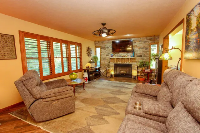 a living room with furniture a fireplace and a large window