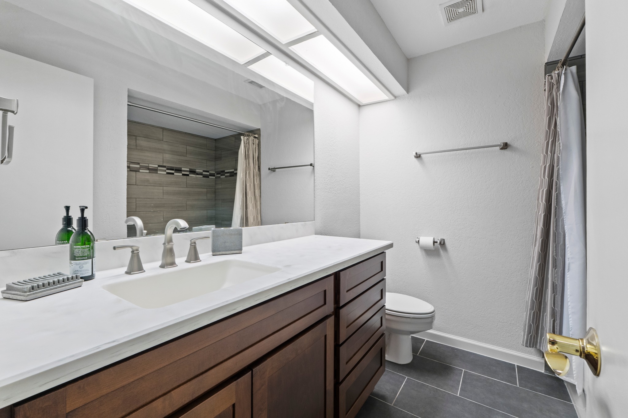 4711 Spicewood Springs Road, Unit 8146 Austin, TX 78759 - Photo 15 of 17 Bathroom with a spacious vanity, dual overhead lighting, dark wood-finish cabinetry, and a single undermount sink