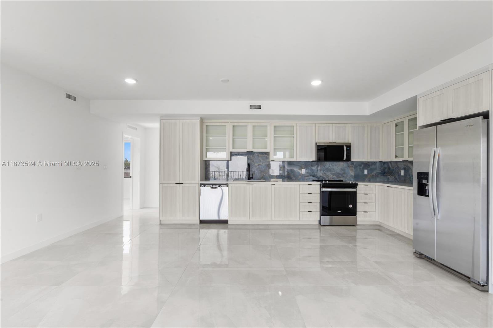 a large kitchen with cabinets and stainless steel appliances