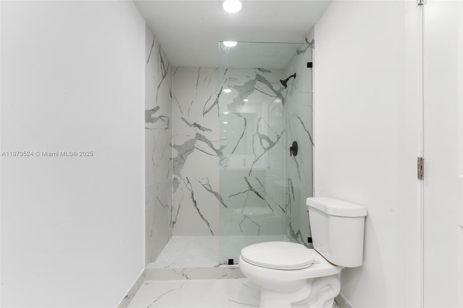 14530 Southwest 261st Terrace, Unit 2 Homestead, FL 33032 - Photo 12 of 23 a white toilet sitting next to a shower curtain