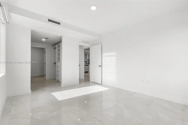 an empty room with closet and a bathroom