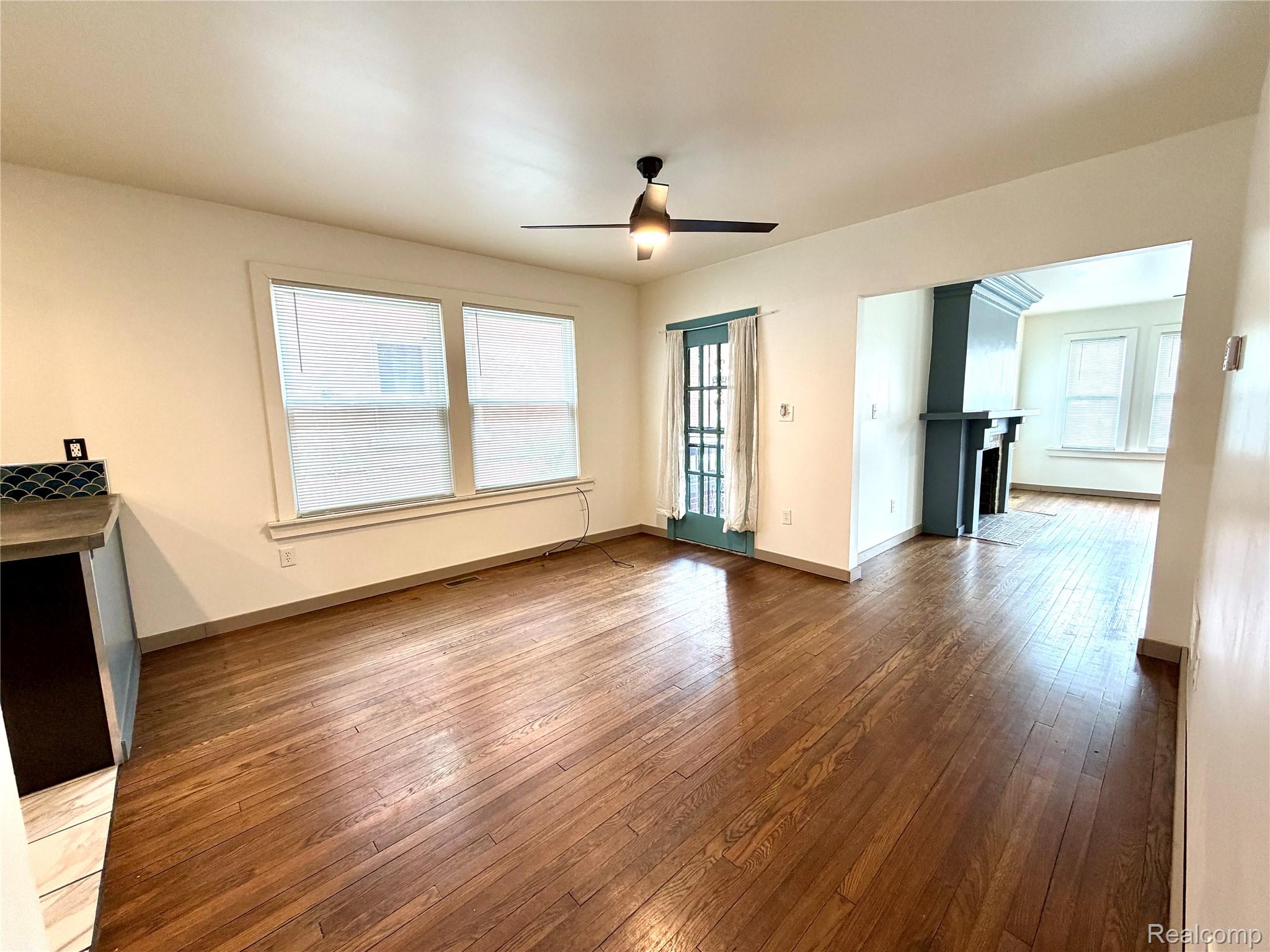 2045 Calvert Avenue Detroit, MI 48206 - Photo 10 of 41 Unfurnished living room with dark wood finished floors, ceiling fan, and a fireplace