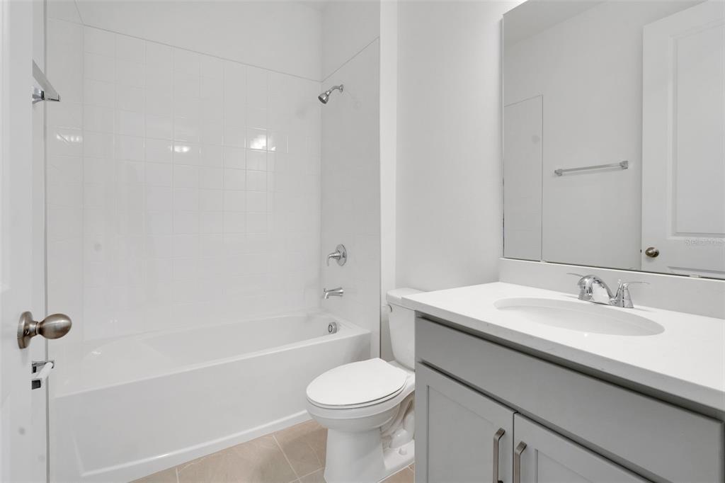 1018 Swamp Chestnut Loop Lady Lake, FL 32159 - Photo 12 of 35 a bathroom with a sink toilet vanity and shower