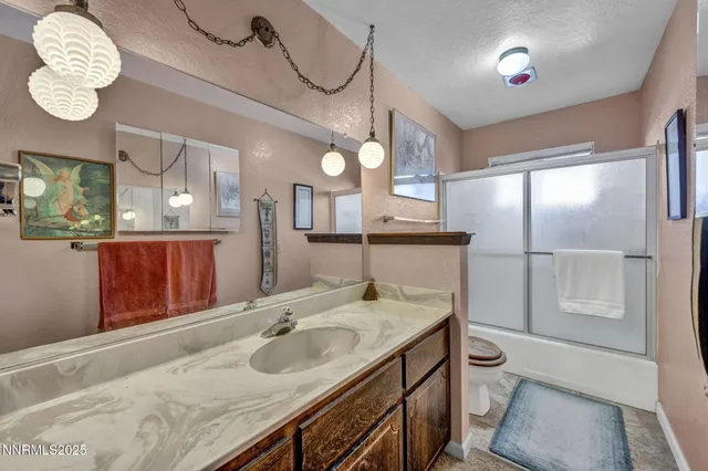 a bathroom with a granite countertop sink a toilet and a mirror