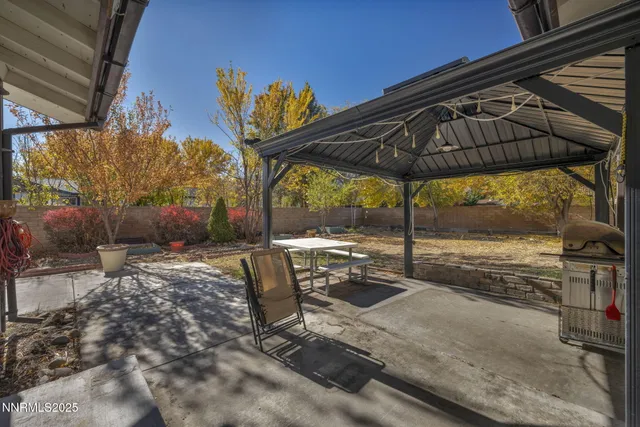 a view of a backyard with table and chairs under an umbrella