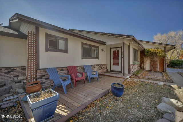 a view of a patio with table and chairs with wooden floor and fence