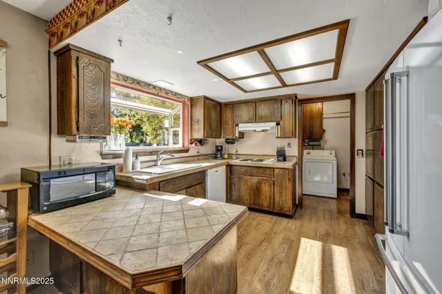 a kitchen with stainless steel appliances granite countertop a sink a stove and refrigerator