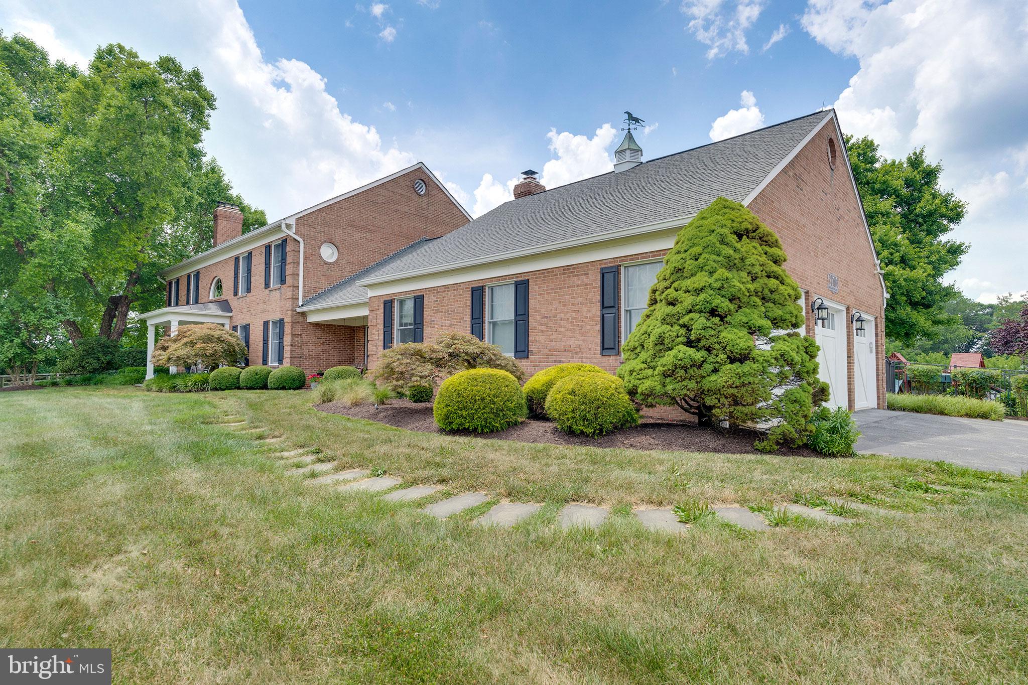 26100 Mullinix Mill Road Mount Airy, MD 21771 - Photo 6 of 99 Charming brick home with lush greenery.