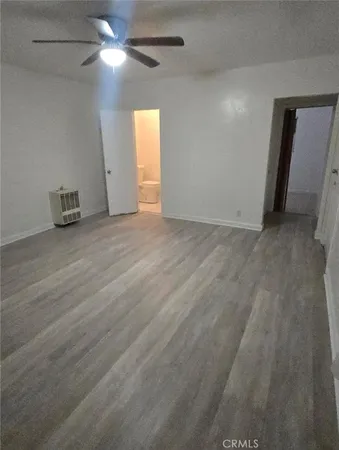 an empty room with closet and a chandelier fan