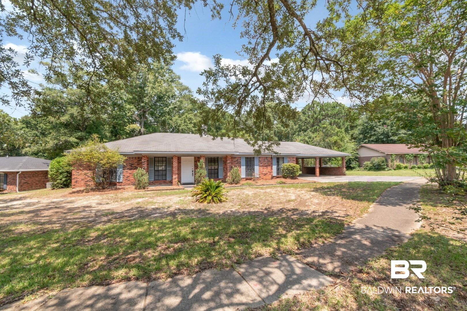 5812 Fern Valley Road Mobile, AL 36609 - Photo 28 of 32 Traditional brick residence featuring a covered front entry, contrasting blue window shutters, and a covered carport