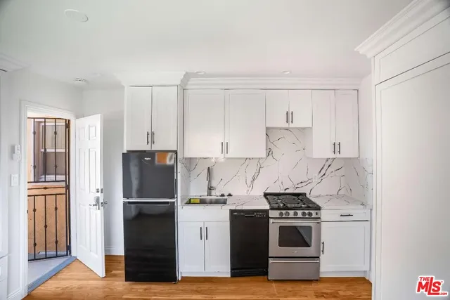 a kitchen with appliances a refrigerator and a cabinets