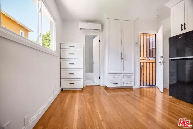 a view of a kitchen with refrigerator and wooden floor