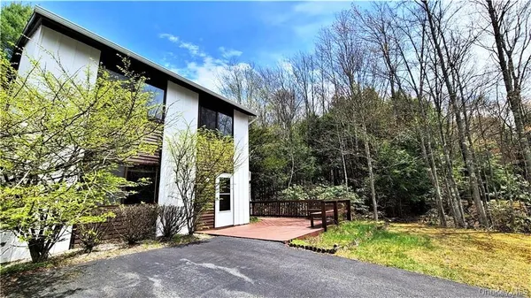 a view of swimming pool with lawn chairs and plants