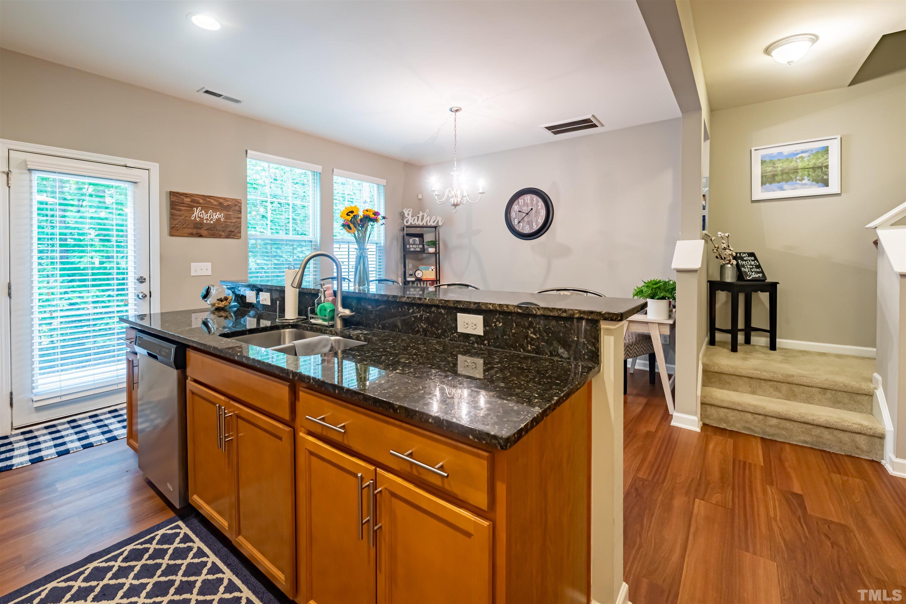 1427 Chatuga Way Wake Forest, NC 27587 - Photo 12 of 36 a kitchen with stainless steel appliances granite countertop a stove and a wooden cabinets